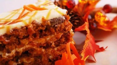 carrot cake on a plate garnished with autumn leaves