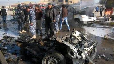 Iraqi policemen inspect the remains of a car used in a bomb attack in Kirkuk, north of Baghdad. Attacks across Iraq unfolded over a two-and-a-hour period which the interior ministry blames on Al Qaeda.