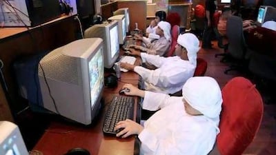 Young boys surf the web at an internet cafe in Abu Dhabi.