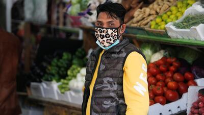 A vendor wears a protective face mask following the coronavirus outbreak, at a local vegetables and fruits market in Sanabis west of Manama, Bahrain. Reuters