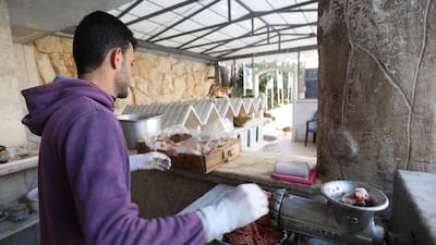 A volunteer grinds mincemeat to feed cats at Ernesto's Cat Sanctuary. AFP