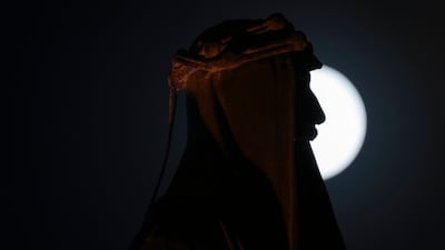 The full moon rises over the statue of King Faisal I, in central Baghdad, Iraq. AP