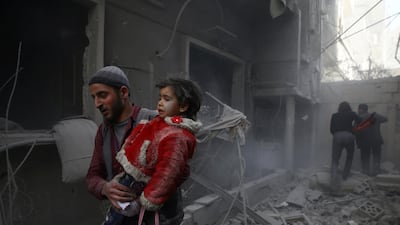 A man holds a child after an airstrike in the government-besieged Syrian town of Douma, in the Eastern Ghouta region near Damascus, on February 7, 2018. Bassam Khabieh / Reuters