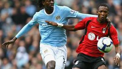 John Pantsil of Fulham holds off a challenge from Emmanuel Adebayor.