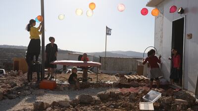 Israeli settlers from the Weinberger family celebrate a birthday in their house at Eviatar.
