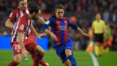 Barcelona midfielder Denis Suarez vies with Atletico Madrid defender Juanfran. Lluis Gene / AFP