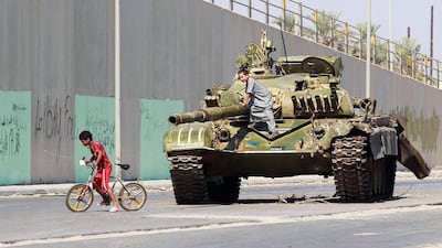 A boy plays on top of a tank belonging to forces loyal to Libyan leader Muammar Gaddafi, which was captured by rebel fighters, in the city centre of Zawiyah, 50 km (31 miles) east of Tripoli August 23, 2011. Libyan rebel forces have breached the first gat???