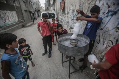 Palestinian children make candy floss in the Shateaa refugee camp in the north west of Gaza City. EPA