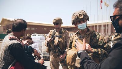 A US Navy medical surgeon talks to an interpreter as he provides medical assistance to a family during an evacuation at Hamid Karzai International Airport in Kabul. AP Photo