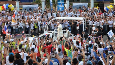 Pope Francis waves to faithfuls from the popemobile, moments after landing at Panama's Tocumen International Airport. AFP