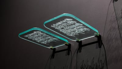 Traces uses engraved glass, light and shadow to turn Juma Al Haj’s inscriptions into shifting fragments of meaning. Victor Besa / The National