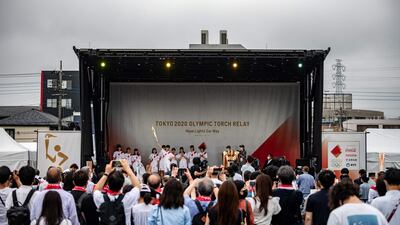 Visitors watch the lighting ceremony of the Olympic flame at Machida Shibahiro.