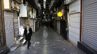 People walk past closed shops following protests in the Tehran Grand Bazaar. Reuters