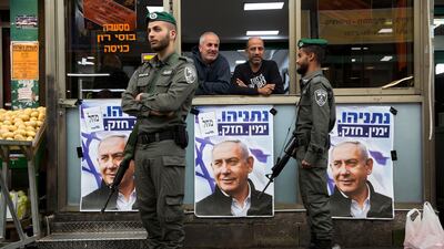 Israeli border police officers stand guard next to posters depicting Israeli Prime Minister Benjamin Netanyahu at the Ha'tikva market in Tel Aviv, Israel. AP