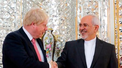 Iran's foreign minister Mohammad Zarif shakes hands with his British counterpart Boris Johnson during a meeting in Tehran. Atta Kenare / AFP