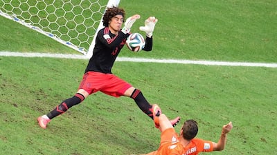 Mexico goalkeeper Guillermo Ochoa, left, makes a save on a shot by Netherlands forward Klaas-Jan Huntelaar during their match on Sunday at the 2014 World Cup in Fortaleza, Brazil. Javier Soriano / AFP