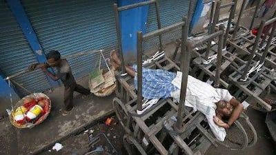 An Indian man sleeps on a handcart in front of closed shops during a nationwide strike in Gauhati over a government decision to open the country’s huge retail market to foreign companies and to cut fuel subsidies.