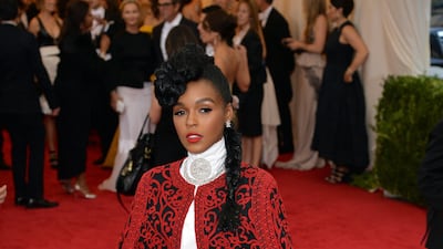 Janelle Monae, wearing a red and black embroidered Tadashi Shoji tulle cape, arrives at the 2014 Met Gala on May 5, 2014. EPA