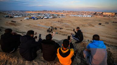 Palestinians attempt to get a mobile phone signal on a hill facing their makeshift camp in Rafah, southern Gaza, in 2024. AFP