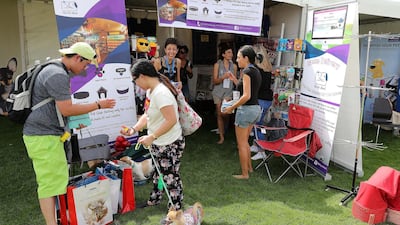 Visitors bring their furry friends to the pet shop at the Abu Dhabi Pet Festival held at du Arena on Yas Island. Pawan Singh / The National