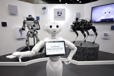 A SoftBank Group robot, centre, a Boston Dynamics Atlas humanoid robot, left, and (right) Spot robot. Bloomberg