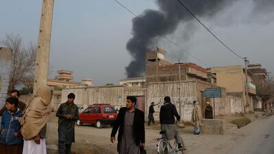 A thick plume of black smoke rises above the compound. Noorullah Shirzada / AFP Photo