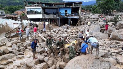 Colombian soldiers carry a victim, in Mocoa, Colombia, Saturday, April 1, 2017, after water from an overflowing river swept through the town as people slept. Colombian Army / AP Photo