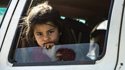 A young Syrian girl fleeing with her family from Ras Al Ain peeks out of a car window as Syrian Arabs and Kurds moving away from the battle zone between Turkey-led forces and Kurdish fighters from the Syrian Democratic Forces (SDF), arrive in the city of Tal Tamr on the outskirts of Hasakeh. AFP