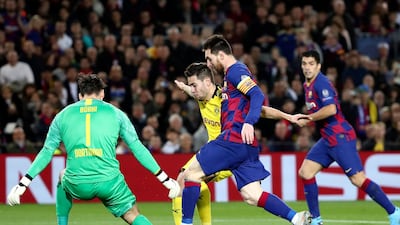 Barcelona's Lionel Messi, center, tries to round Dortmund goalkeeper Roman Burki. AP