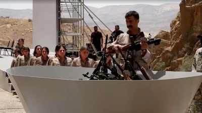 A PKK fighter hands over a weapon to be burnt at a disarmament ceremony in Sulaymaniyah, Iraq. Reuters