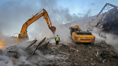 Iranian firefighters remove debris of the Plasco building which collapsed on Thursday, in central Tehran. Scores of workers and dozens of trucks were searching the ruins days after the historic high-rise building in the heart of Tehran caught fire and later collapsed. Ebrahim Noroozi / AP Photo