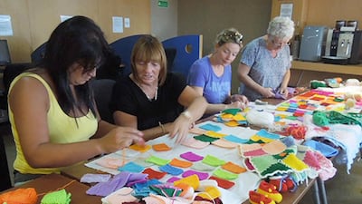 Volunteer knitters craft squares to be sewn together for blankets to be sent to Syrian refugee mothers and babies. Courtesy of Sandra Patricia Abo El Nour