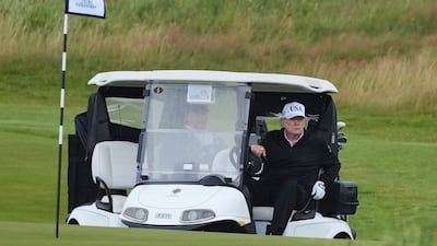 Mr Trump steers a golf buggy at Trump Turnberry. AP Photo