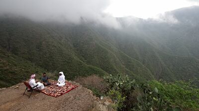Men enjoy their afternoon tea in cool temperatures in the mountains of Rijal Almaa, Saudi Arabia. Reuters