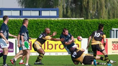 Steve Thompson of the Gulf Legends, third from the right, passes the ball before falling to the ground as they took on the J9 team on Day 2 at the Dubai Rugby Sevens. Victor Besa for The National