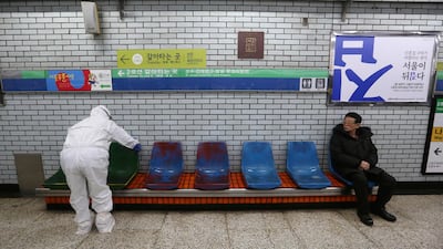 A worker wearing protective gears disinfect chairs as a precaution against the coronavirus at a subway station in Seoul. AP Photo