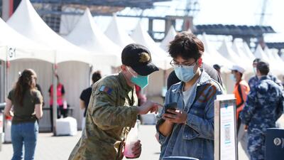 A member of the Australian Defence Force assists people arriving at a vaccination centre in Sydney.