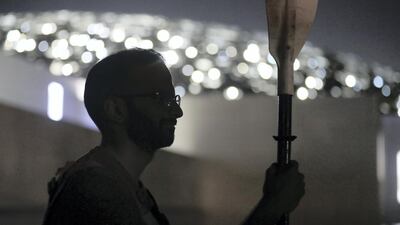 The dome of Louvre Abu Dhabi sparkles behind a kayaker. Chris Whiteoak / The National