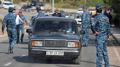 Refugees from Nagorno-Karabakh region drive cars past an Armenian checkpoint. Armenia's Prime Minister has warned of ethnic cleansing and accused Russia of failing to provide security. Reuters