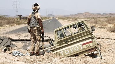 A Yemeni fighter loyal to the president stands next to an army pickup truck as it lies in a hole on the road leading to Khaled Ibn Al Walid on April 15, 2017. AFP / Saleh Al Obeidi