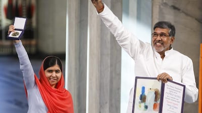 Nobel Peace Prize winners Malala Yousafzai from Pakistan and Kailash Satyarthi of India hold up their Nobel Peace Prize during the award ceremony in Oslo, Norway on December 10, 2014. Heiko Junge/AP Photo