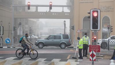 Cleaners work on an intersection in the marina. Antonie Robertson / The National.