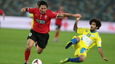 Al Ahli’s Luis Antonio, right, challenges Al Dhafra’s Abdalla Al Naqbi for possession of the ball during a President’s Cup semi-final match in Abu Dhabi on Thursday night. Christopher Pike / The National