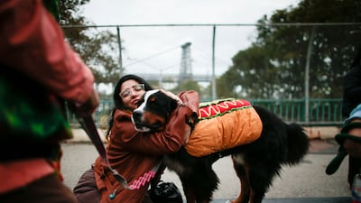 A woman hugs a dog in a hot dog costume during the parade. AFP