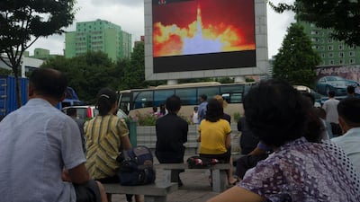 This photo taken on July 29, 2017 shows people watching as coverage of an ICBM missile test is displayed on a screen in a public square in Pyongyang. Kim Won-jin / AFP