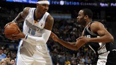The Denver Nuggets forward Carmelo Anthony moves past the San Antonio Spurs guards Roger Mason, centre, and George Hill in the fourth quarter of Tuesday's NBA game.