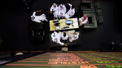 Emirati traders check the stocks of Emaar Malls on the screen at the Dubai Financial Market. Kamran Jebreili / AP Photo