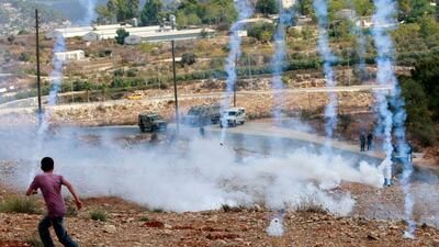 Tears of fear: a Palestinian protester runs from tear gas during a weekly protest against the expansion of the nearby Jewish settlement of Halamish, in the West Bank village of Nabi Saleh near Ramallah. Majdi Mohammed / AP Photo
