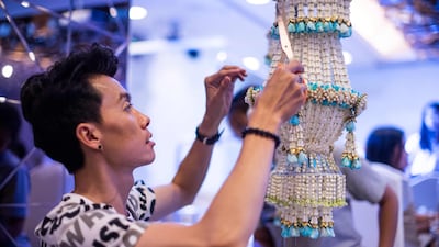 A Thai man helps put together an elaborate decoration during a fruit and vegetable carving competition in Bangkok. Robert Schmidt / AFP