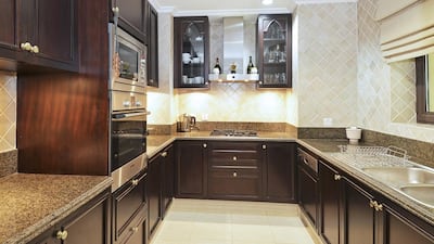 The open-plan living area includes a fully-fitted dark wood kitchen complete with white goods and a dining and living area separated by an attractive alcove. Courtesy Better Homes